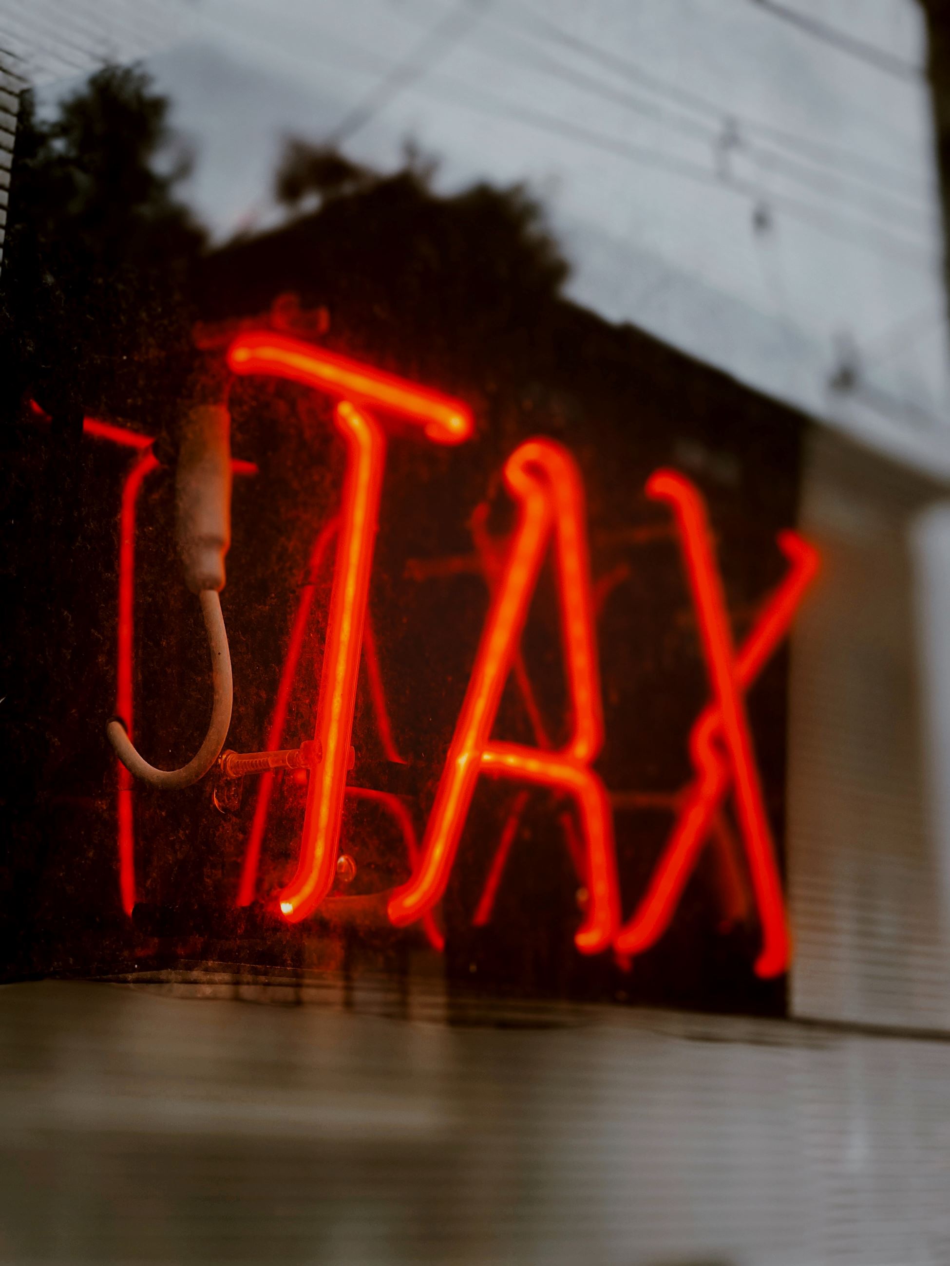 Neon Sign in window that says Tax